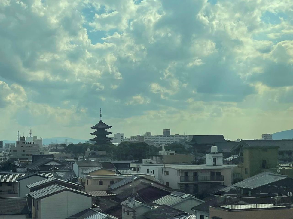The city of Kyoto through the bullet train window, a pagoda rises among office and residential buildings